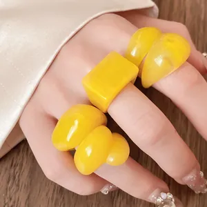 Macro detail of chunky yellow resin marbled rings with a glossy finish for women