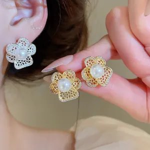 Detail view of French vintage hollow flower pearl earrings with zircon accents