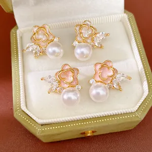 Primer plano de elegantes pendientes de flores y perlas en un joyero de terciopelo