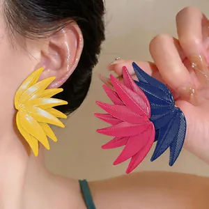 Detailed macro view of vibrant leaf-textured statement earrings in pink and blue