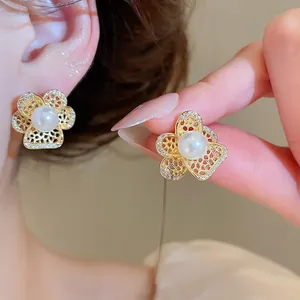 Close-up of elegant French vintage hollow flower earrings featuring pearl and zircons