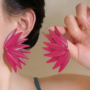 Detailed close-up of magenta leaf-patterned stud earrings with natural vein texture