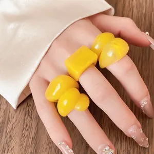 Close-up detail of stylish yellow marbled resin rings set in various geometric shapes