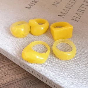 Detailed view of yellow resin rings with unique geometric and duck shapes