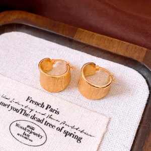 Detailed macro view of brushed 18k gold plated minimalist round hoop earrings