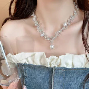 Close-up of elegant French style pearl necklace with intricate beadwork on model.