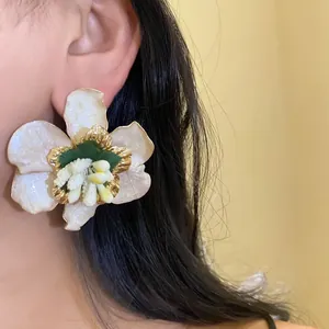 Primo piano di un orecchino a fiore in stile bohémien indossato da una modella