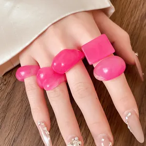 Close-up detail of vibrant neon pink resin rings with marble swirl effect on hand
