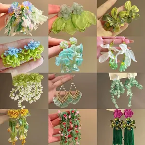 Elegant green chiffon flower tassel earrings with various handmade beaded floral designs.