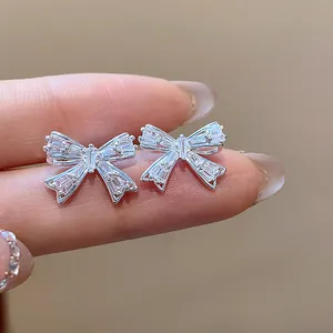 Exquisite Makro-Detailansicht funkelnder Zirkonia-Schleifen-Ohrklemmen für Damen