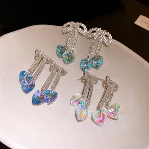 Macro detail view of sparkling bow earrings featuring heart-shaped iridescent crystals.