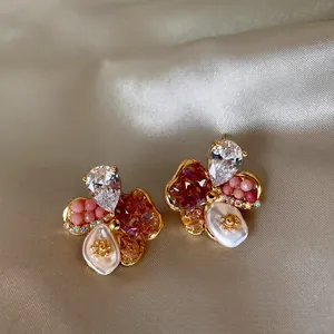 Gros plan détaillé de boucles d'oreilles vintage fleurs en verre coloré sur du satin