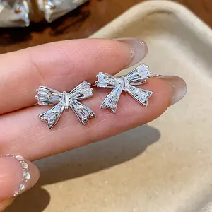 Detailaufnahme von funkelnden silbernen Schleifen-Clip-Ohrringen mit elegantem Zirkonia-Inlay.