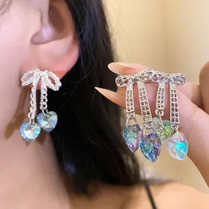 Close-up detail of the iridescent heart crystal tassels and sparkling bow design on earring