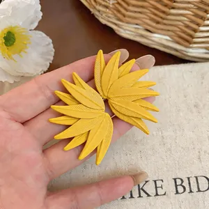 Close-up of yellow leaf textured earrings featuring matte finish and bold nature design