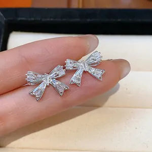 Detaillierte Nahaufnahme von funkelnden Zirkonia-Schleifenohrringen mit edlem Silberfinish.