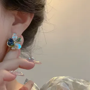 Gros plan de boucles d'oreilles fleurs de luxe avec des pétales de verre colorés