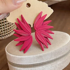 Close-up showing the intricate leaf texture and vibrant pink color of the stud earrings.
