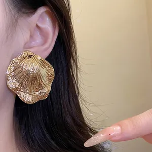 Large gold metal wrinkled leaf stud earrings with textured metallic finish