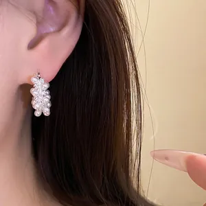 Elegant 18k gold plated cluster pearl and zircon earrings showcased on a model's ear