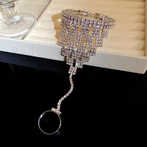 Vista ravvicinata di un bracciale anello con strass scintillanti e frange eleganti in argento