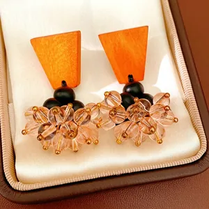 Handmade ethnic style earrings with orange wood trapezoid and faceted glass bead clusters