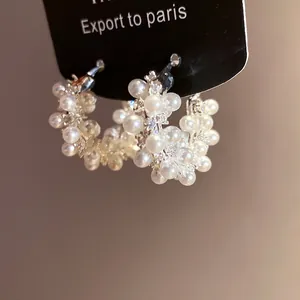 Macro view of pearl and zircon details on elegant 18k gold plated hoop earrings