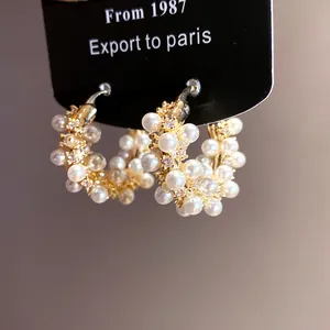Close-up of 18k gold plated hoop earrings with clustered pearls and zirconia