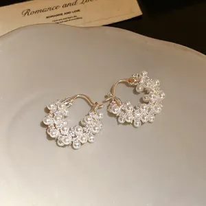 Detailed view of 18k gold plated hoop earrings with shimmering pearls and zircons