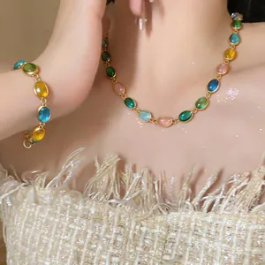 Gros plan d'un modèle portant un ensemble collier et bracelet rétro en résine ovale.