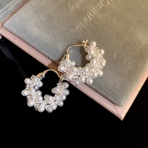 Elegant 18k gold plated hoop earrings with clusters of white pearls and sparkling zircons.