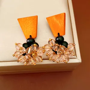 Detailed view of vintage ethnic earrings with orange wood and glass bead tassels