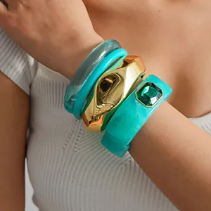 Ensemble de bracelets en résine turquoise et métal doré sur le poignet