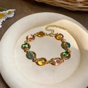 Vue détaillée d'un bracelet vintage doré orné de perles ovales colorées en résine