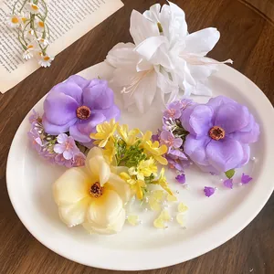 Close-up of elegant handmade fabric flower hair clips with delicate pearl tassel details