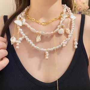 Collana a strati stile vacanza con perle e ciondoli a conchiglia su una modella.