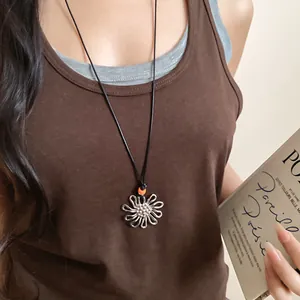 Silver flower pendant necklace with orange bead on model for summer fashion style