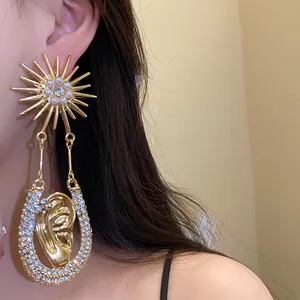 Primo piano di orecchini a sole dorati esagerati con perle e strass sul modello