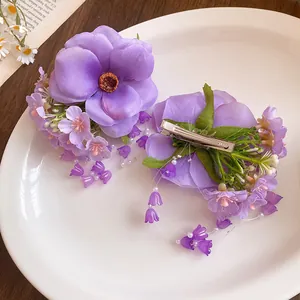 Detailed macro view of purple fabric flower hair clip with pearl tassels and beads