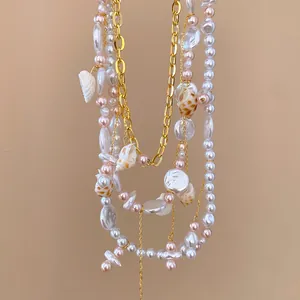 Primo piano di collana a più strati in stile spiaggia con perle bianche e ciondoli a conchiglia