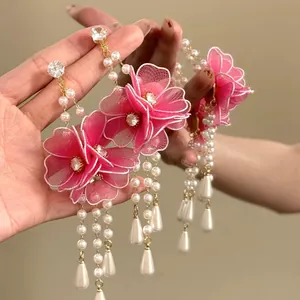 Detailed view of pink mesh flower earrings with pearl tassels and zircon accents