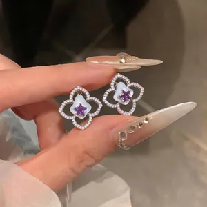Elegantes pendientes de flor de plata con circonitas y detalle de estrella morada