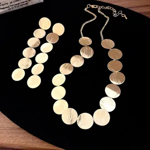 Elegant gold-textured round disc necklace and drop earrings jewelry set for women.