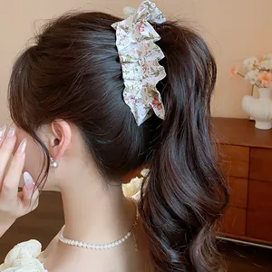 Close-up of a floral fabric twist hair clip styled in a classic ponytail for women