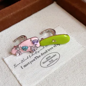Close-up detail of pink and lime green enamel heart zircon ear cuffs for women