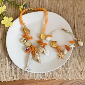 Detailansicht eines Strandurlaub-Schmucksets mit Muscheln, Seesternen und Fischmotiven