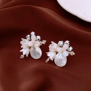 Detailed macro of crystal flower earrings with shell petals and pearl drops