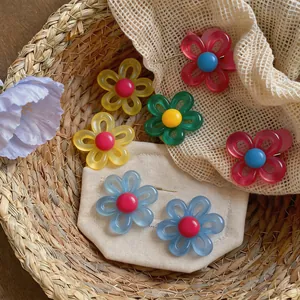 Plusieurs boucles d'oreilles fleurs colorées présentées dans un panier d'été tressé