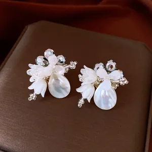 Detailed view of elegant crystal and shell flower drop earrings with a pearlescent finish