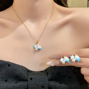 Close-up view of blue enamel starfish necklace and earring set with zircon and pearls